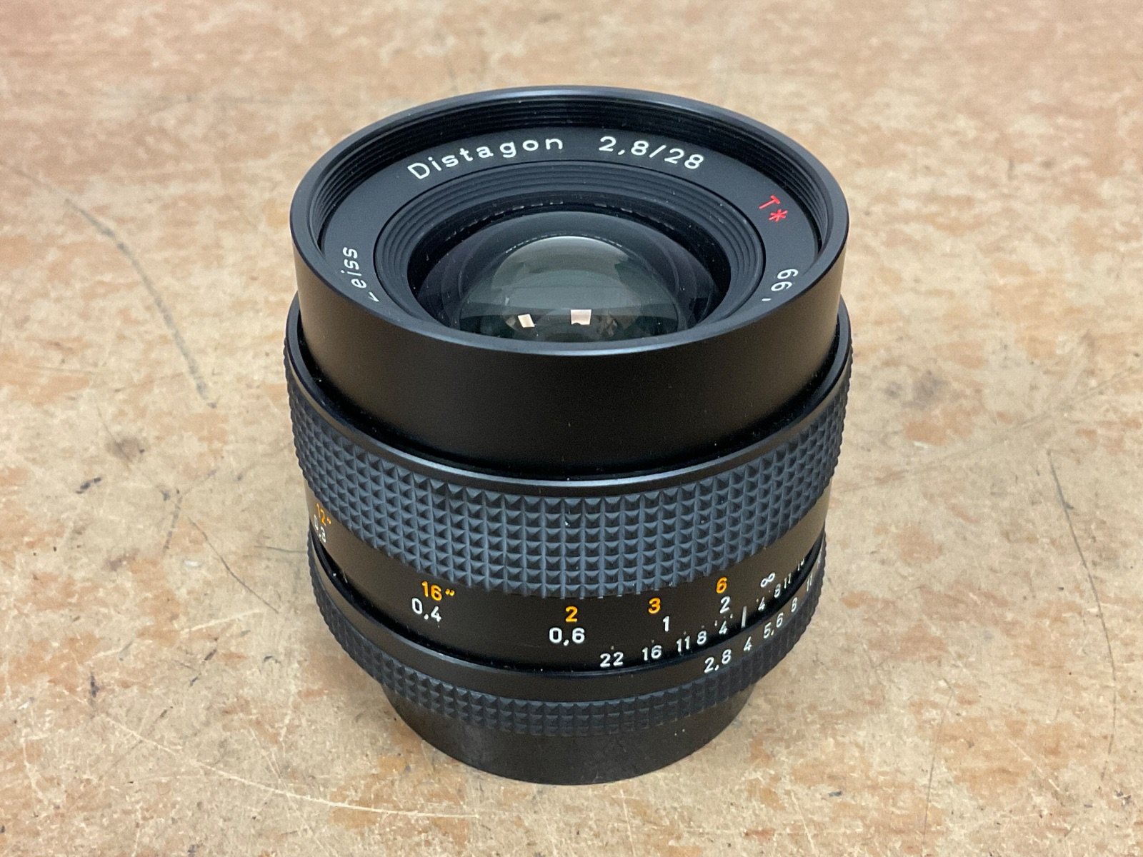 Carl Zeiss Distagon 28mm f/2.8 T* manual focus camera lens in good condition, featuring a textured black and silver design with clear glass.